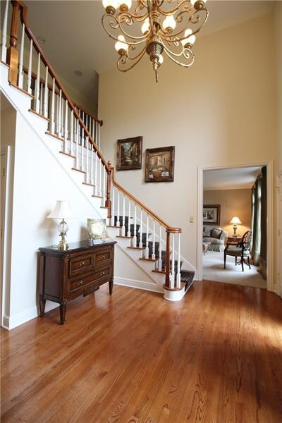 The two story foyer features gleaming wood floors,