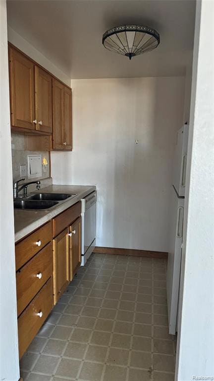 Kitchen with brown cabinets, light countertops, white appliances, and decorative backsplash