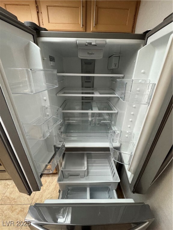 Room details with brown cabinets and fridge