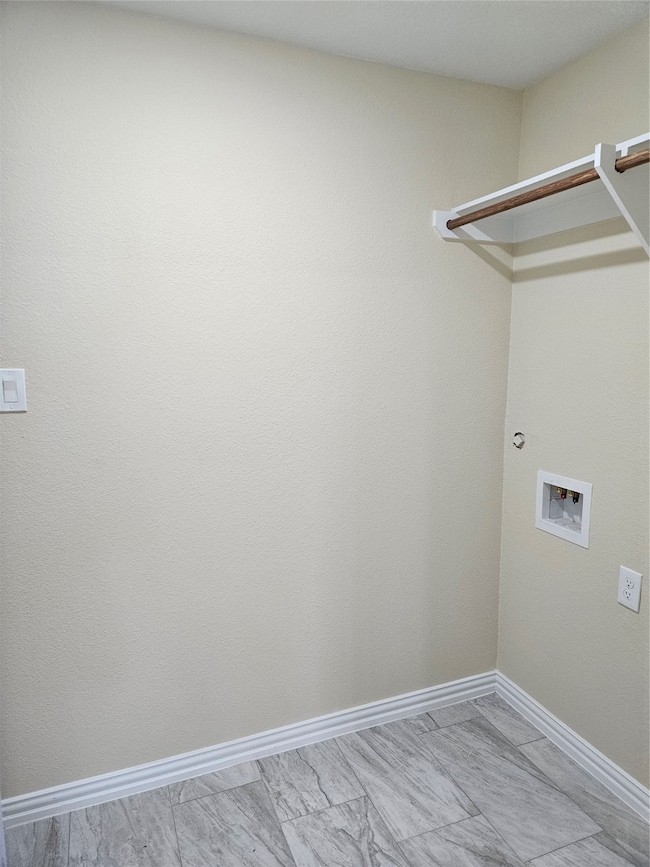 Laundry room featuring baseboards and washer hookup