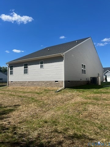 Back of house featuring crawl space and a lawn