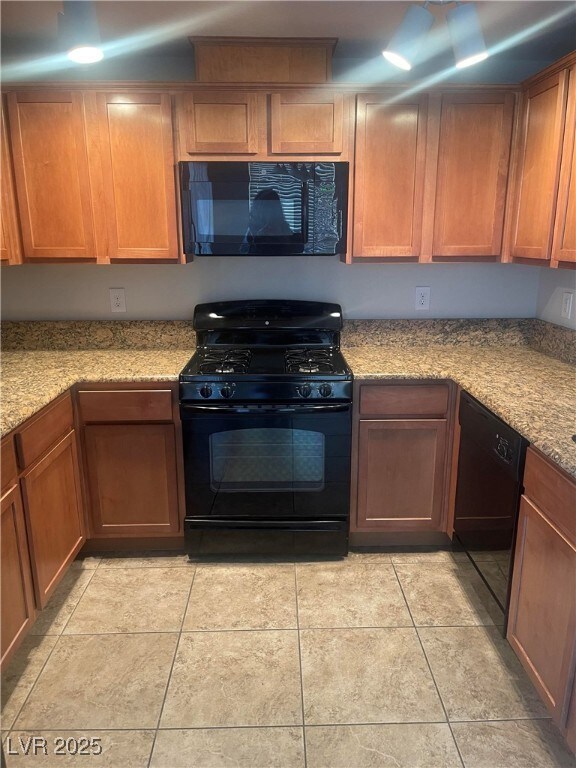 Kitchen with light tile patterned floors, black ap
