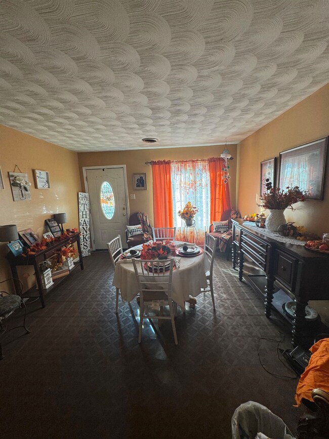 Carpeted dining room featuring a textured ceiling