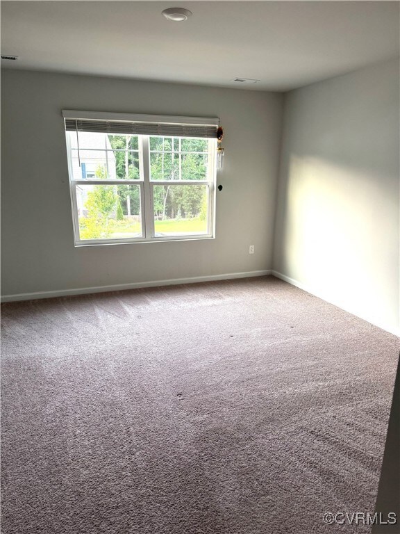Carpeted empty room with baseboards