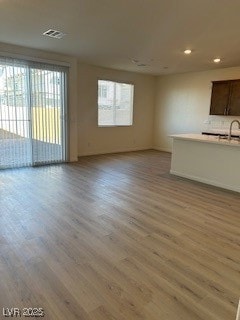 Unfurnished living room featuring light wood finished floors, plenty of natural light, and recessed lighting