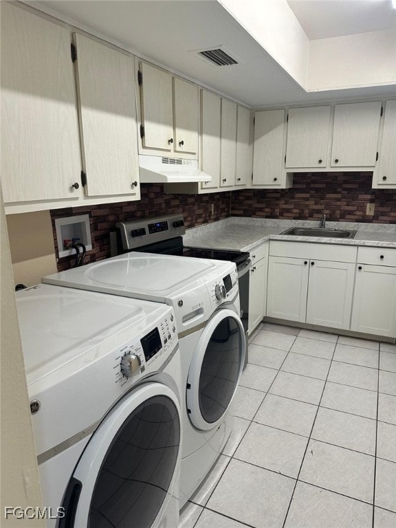 Washroom featuring light tile patterned floors and independent washer and dryer