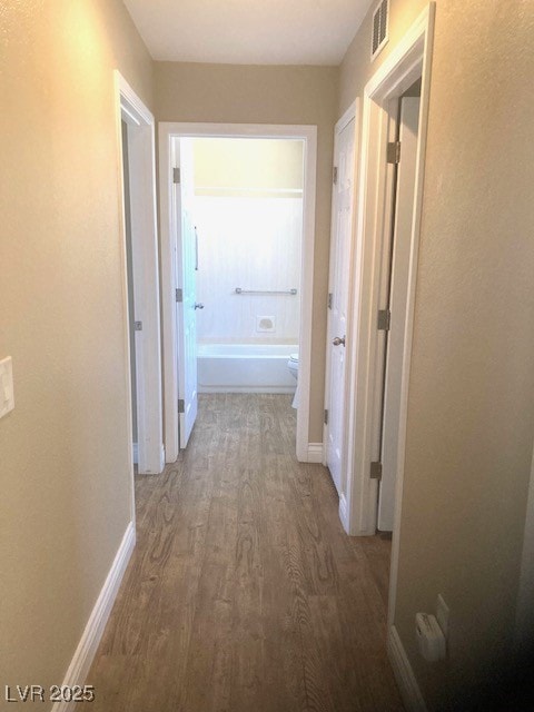 Hallway with wood finished floors and baseboards
