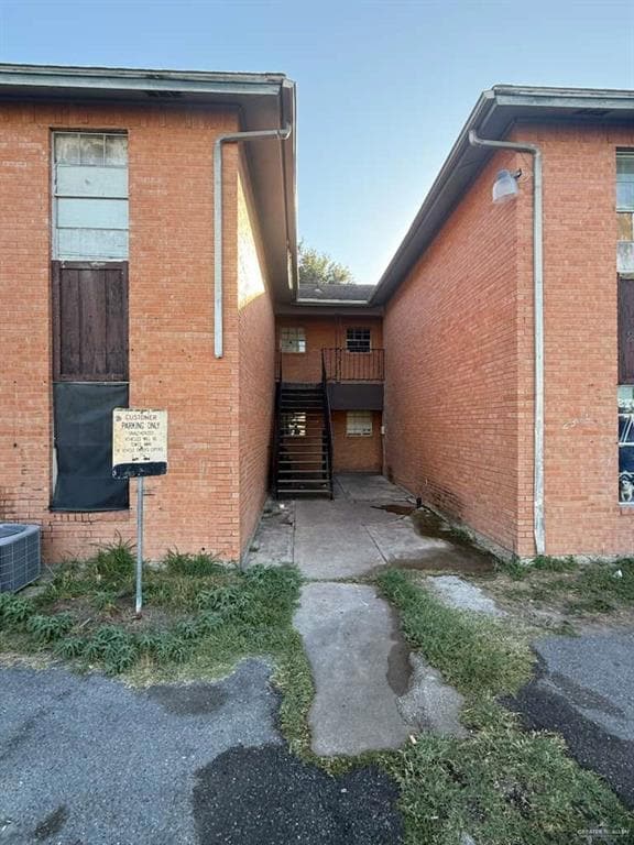 View of side of home with stairs and brick siding