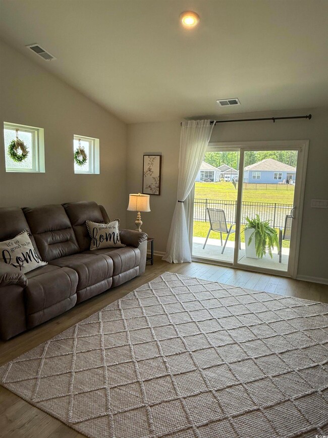 Living area with wood finished floors, lofted ceil