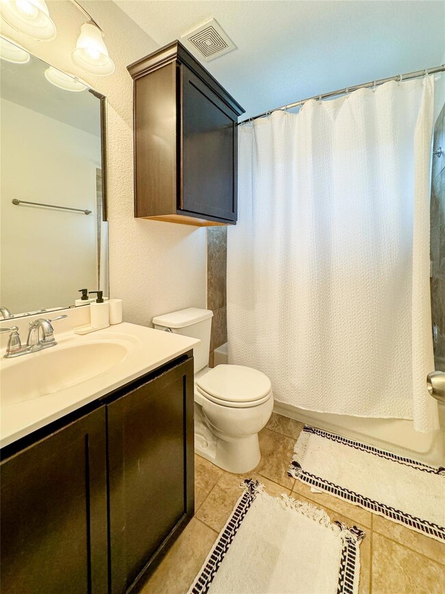 Bathroom with vanity, toilet, tile patterned floo