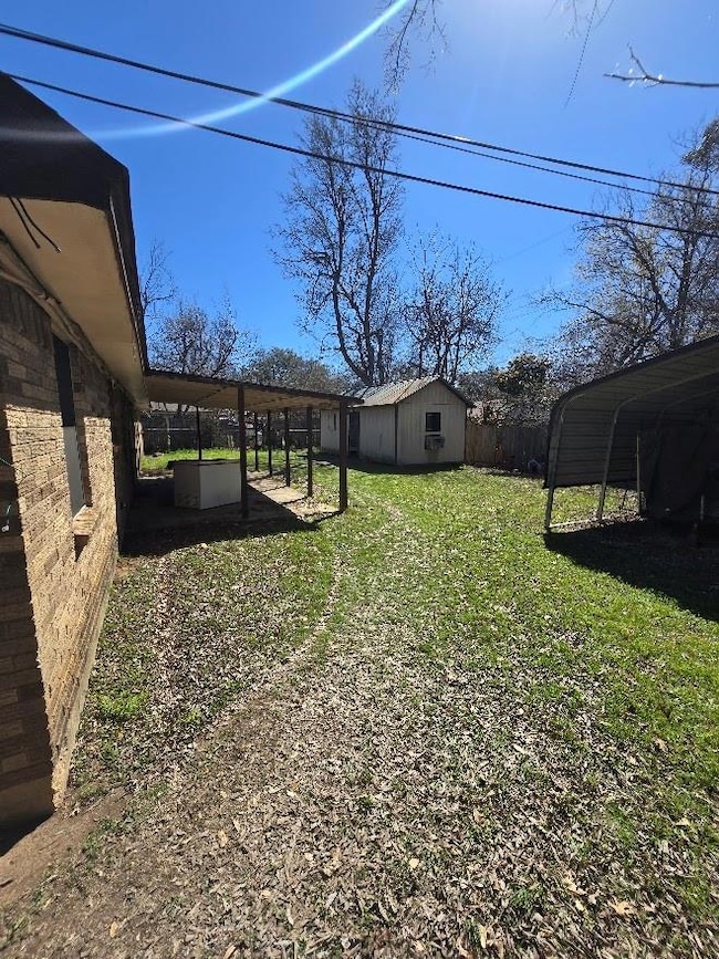 View of yard featuring an outdoor structure and fe