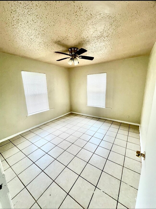Unfurnished room featuring ceiling fan, light tile