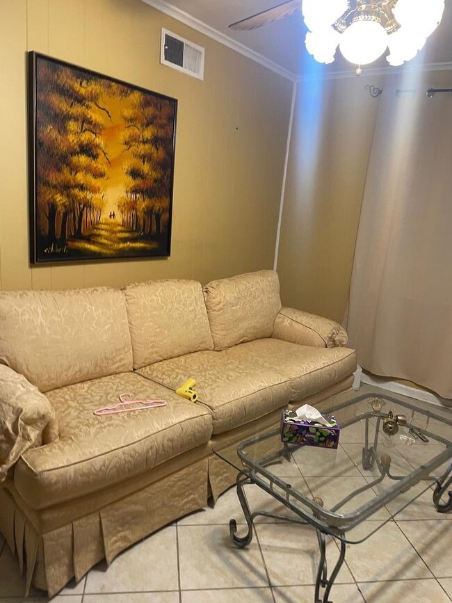 Tiled living room with ceiling fan and ornamental 