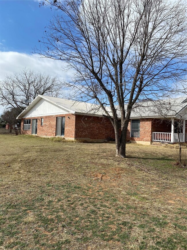 View of property exterior with a yard