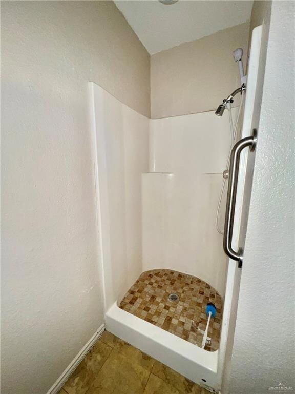 Bathroom with tile patterned floors and a shower stall