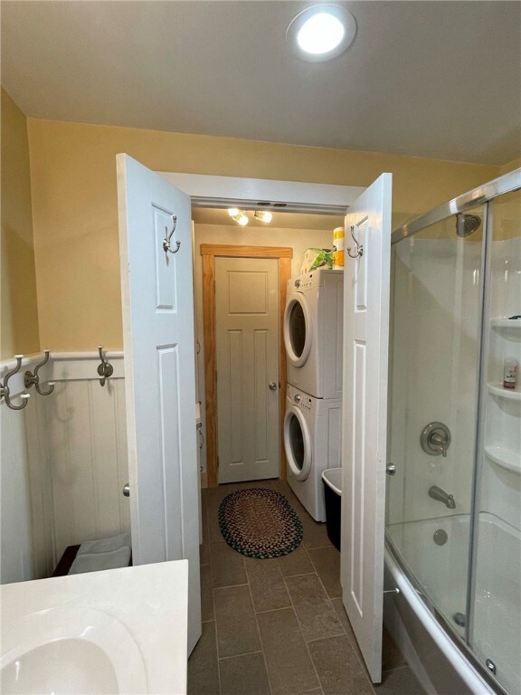 First floor full bath view with laundry area and u