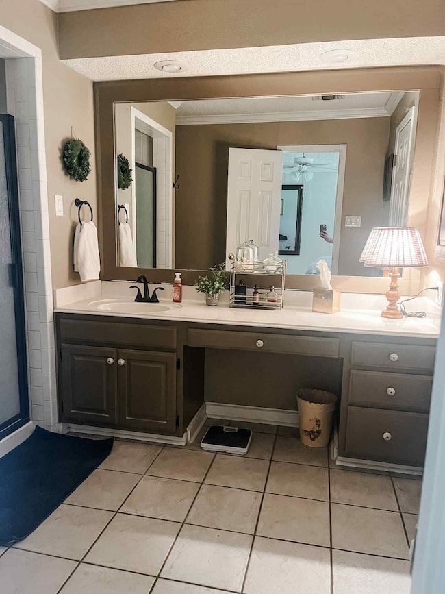 Full bathroom featuring ornamental molding, double vanity, tile patterned flooring, and ceiling fan