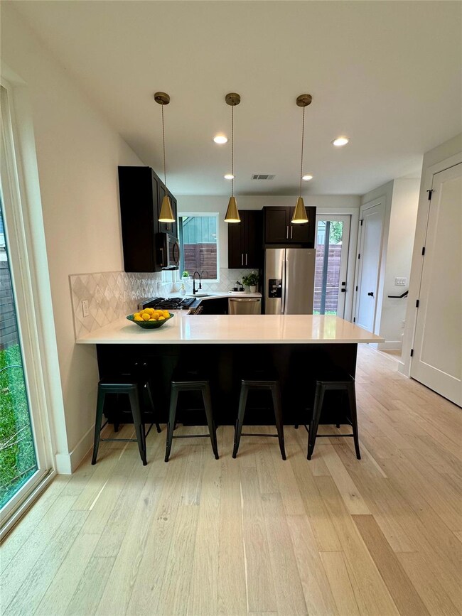 Kitchen featuring stainless steel appliances, lig