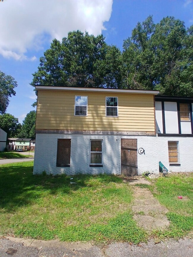 View of side of property featuring brick siding and a lawn