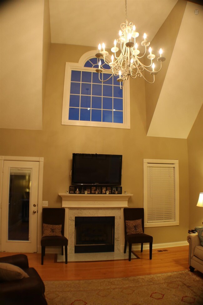 Soaring Living room with fireplace and door to 12x24 deck overlooking spacious backyard. 