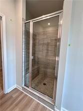 Bathroom featuring a stall shower and wood finished floors