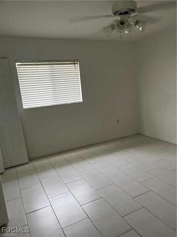 Spare room with light tile patterned flooring and ceiling fan