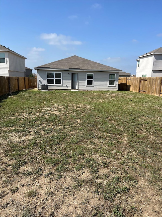Back of property featuring a lawn, a fenced backy