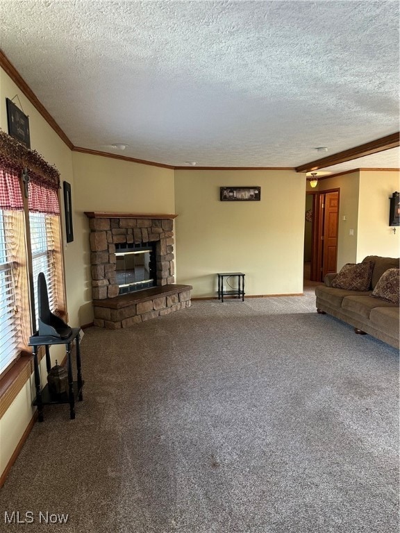Living area featuring ornamental molding, a textured ceiling, a stone fireplace, and dark colored carpet