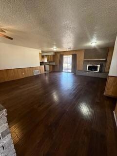 Unfurnished living room featuring wooden walls, da