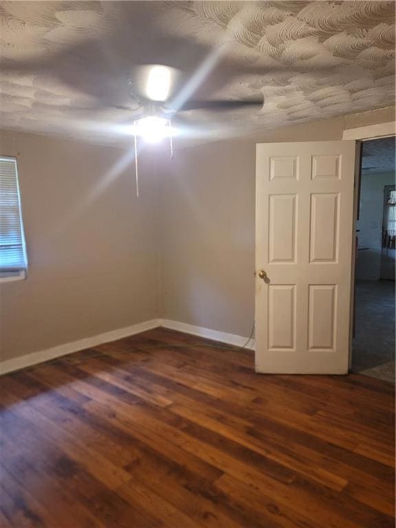 Spare room with dark wood-type flooring