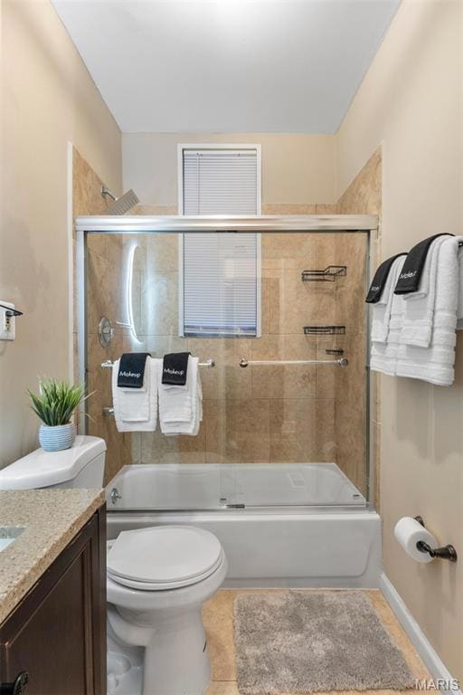Bathroom with enclosed tub / shower combo, vanity, and tile patterned flooring