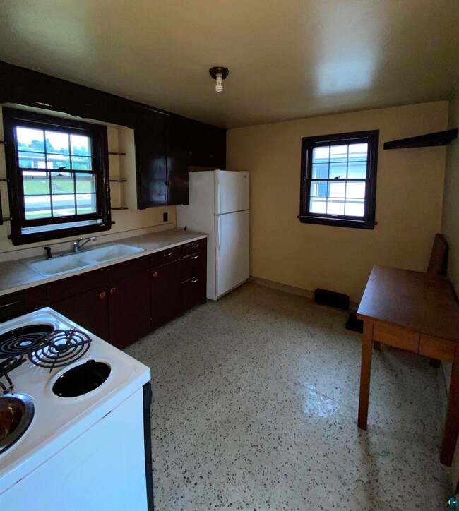 Kitchen with sink, stove, and white refrigerator