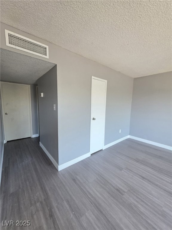 Empty room featuring dark wood-type flooring and a