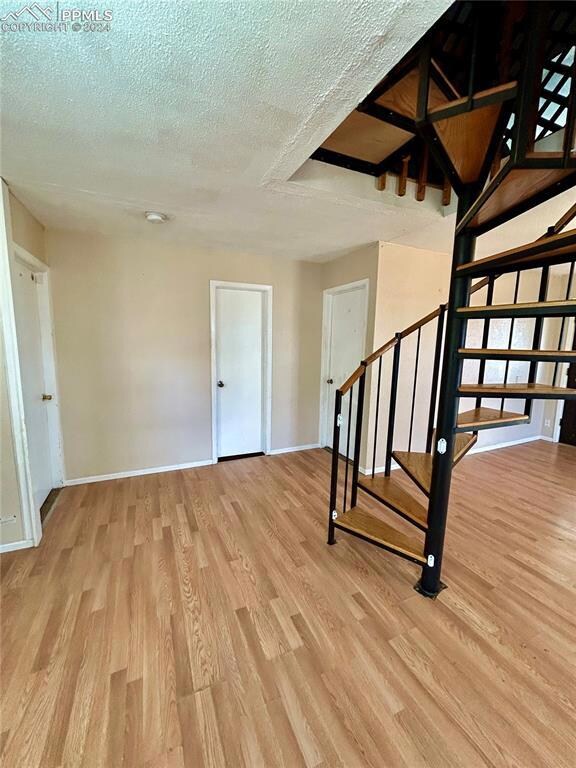 Stairway with light wood-type flooring and a textu