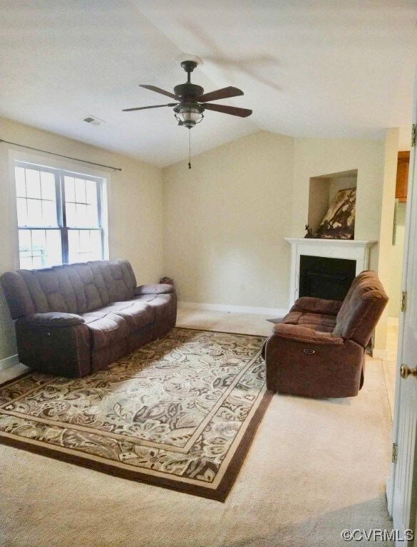 Living room featuring lofted ceiling, ceiling fan,