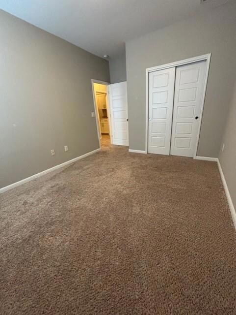 Unfurnished bedroom with a closet, baseboards, an