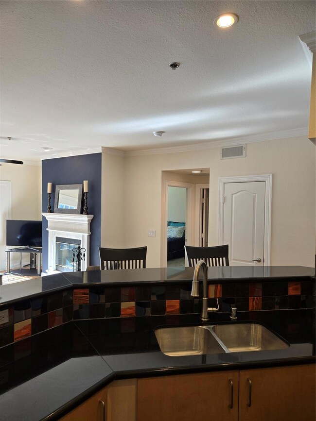 Kitchen looking towards living area, fireplace.