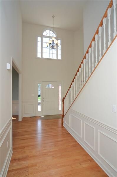 The large inviting two story foyer includes hardwo