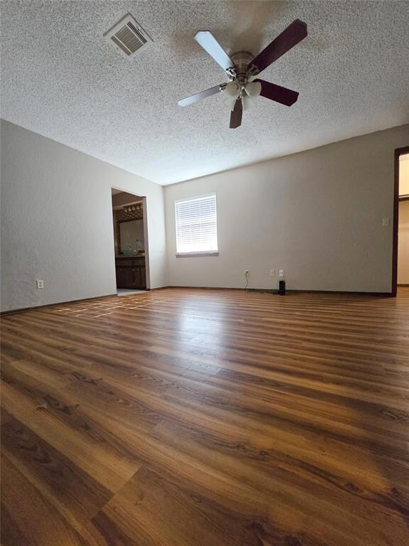 Unfurnished living room with wood-type flooring, a textured ceiling, and ceiling fan