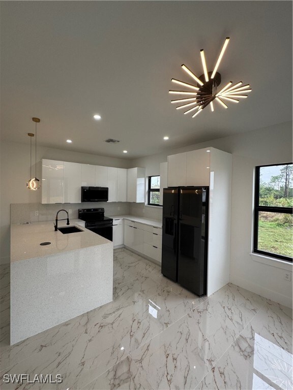 Kitchen with sink, stove, fridge, white cabinets,