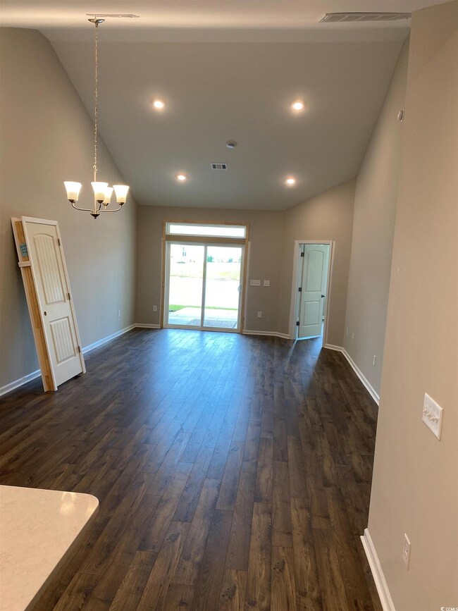 Unfurnished living room featuring dark hardwood / 