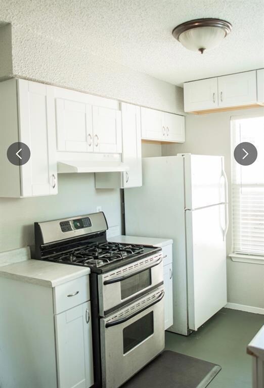 Kitchen with range with two ovens, light countert