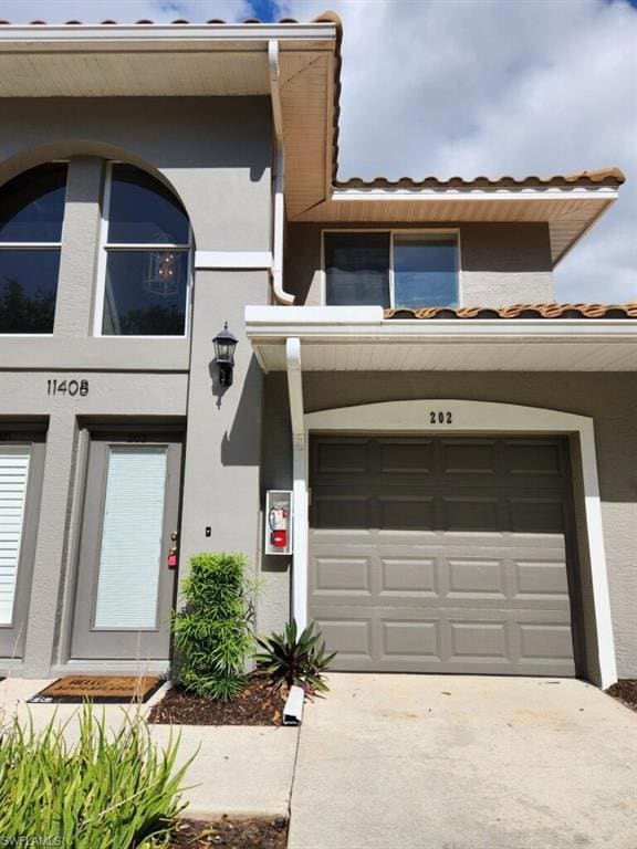 View of front facade with concrete driveway, stucc