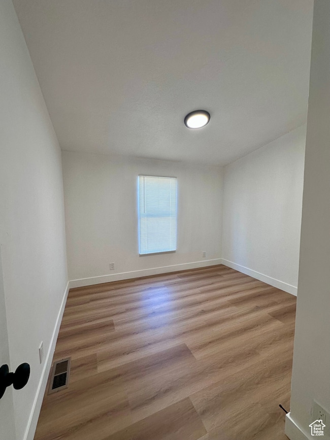 Unfurnished room with light wood-style flooring and baseboards