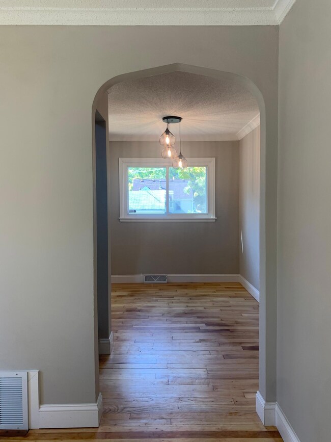 Dining room with beautiful arched doorways and pendant dinging room lighting.