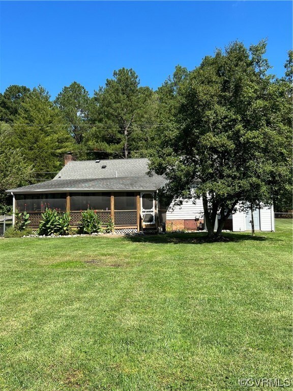View of back of home with large screened in porch