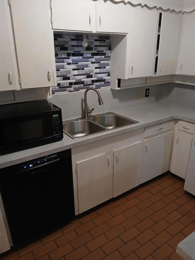 Kitchen with sink, decorative backsplash, white ca