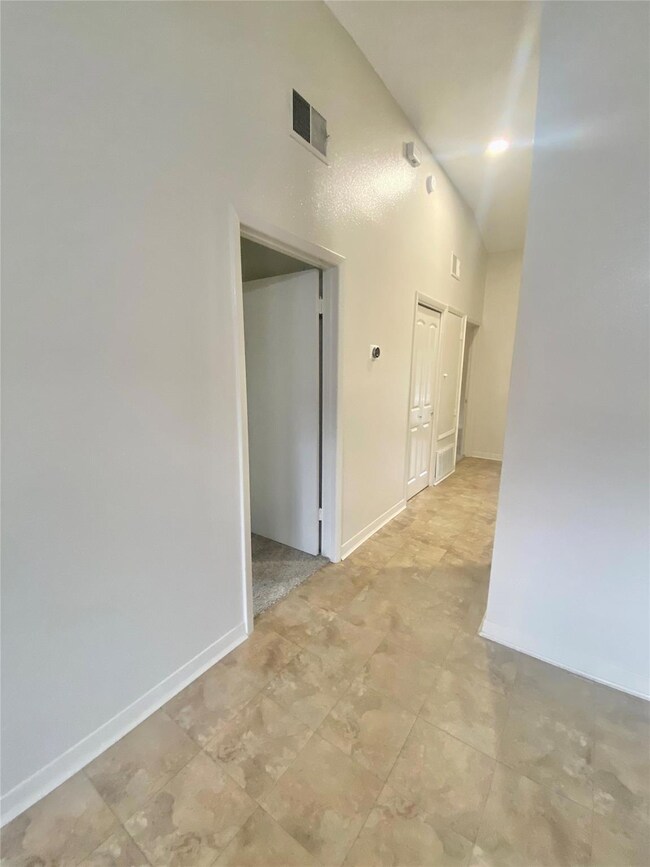 Corridor featuring a towering ceiling, visible ve