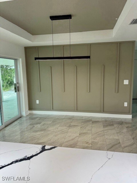 Unfurnished bedroom with a raised ceiling, access