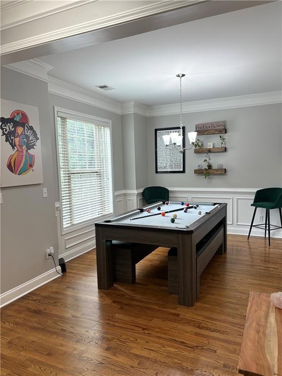 Game room with wood finished floors, ornamental molding, and a decorative wall